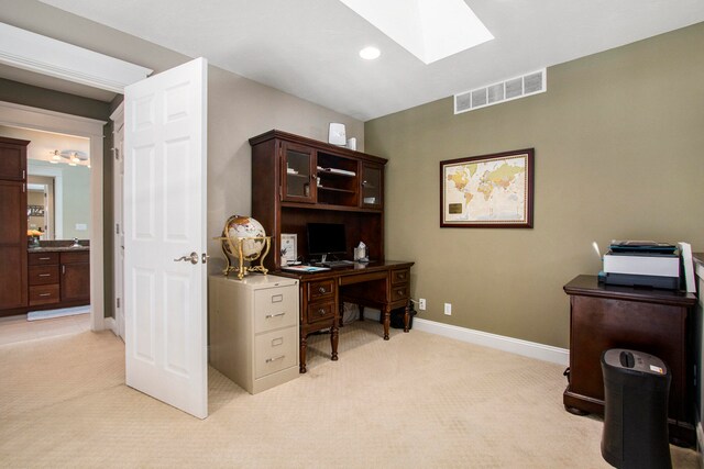 carpeted office featuring a skylight