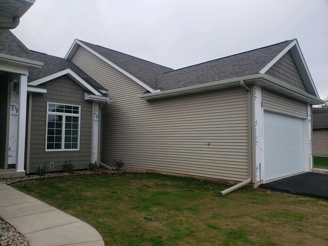 view of home's exterior featuring a lawn and a garage