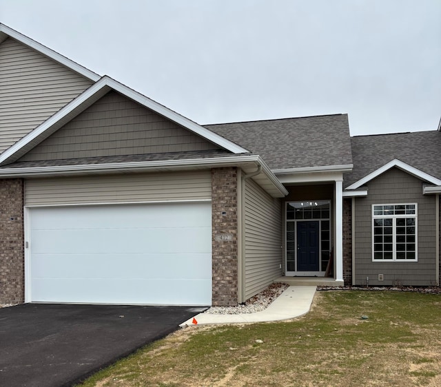 412 Coventry Rd, Battle Creek, MI 49015 - single story home with aphalt driveway, an attached garage, a front yard, brick siding, and roof with shingles