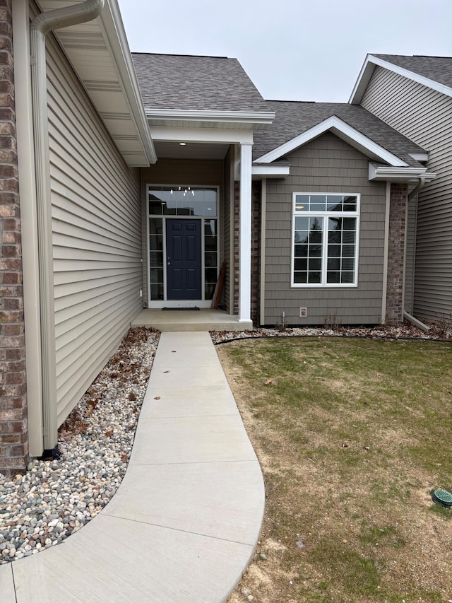 412 Coventry Rd, Battle Creek, MI 49015 - doorway to property featuring a shingled roof and a lawn