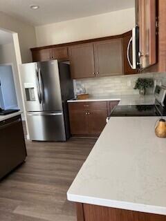 412 Coventry Rd, Battle Creek, MI 49015 - kitchen featuring light countertops, stainless steel appliances, decorative backsplash, and wood finished floors