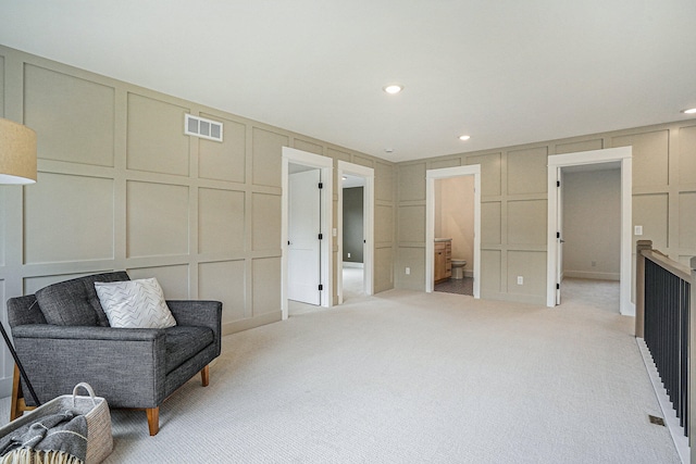 sitting room featuring light colored carpet