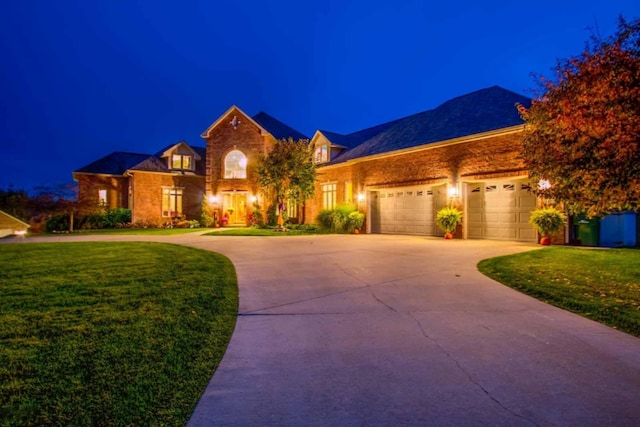 view of front of home with a garage and a lawn