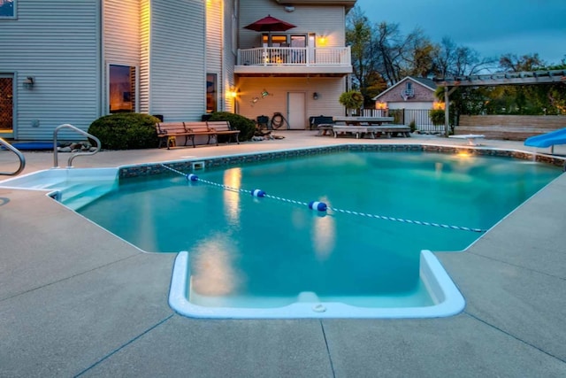 view of pool featuring a patio, a water slide, and a diving board