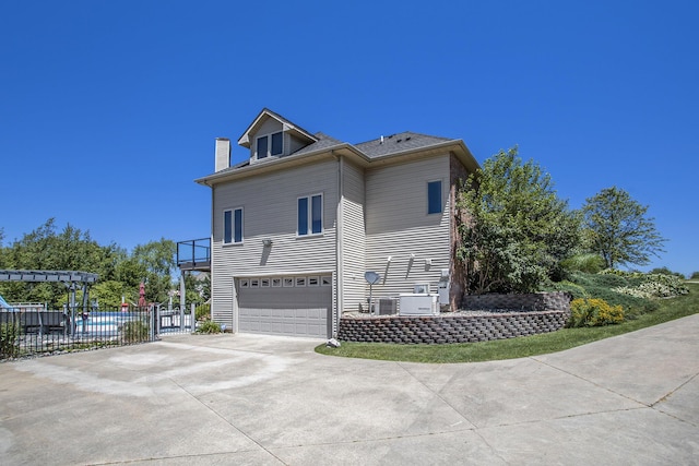 view of property exterior featuring a garage and central air condition unit