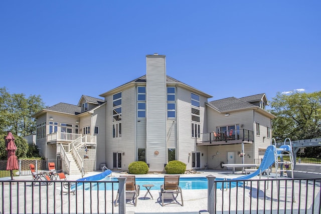 view of swimming pool with a water slide and a patio