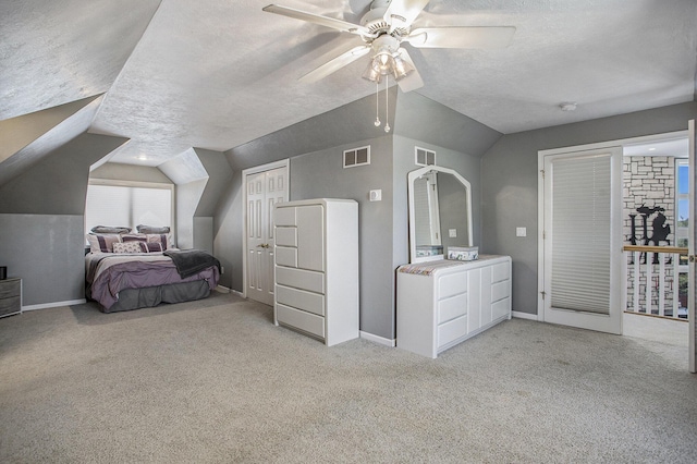 carpeted bedroom featuring lofted ceiling, a textured ceiling, and ceiling fan