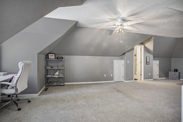 unfurnished office with carpet floors, ceiling fan, and vaulted ceiling