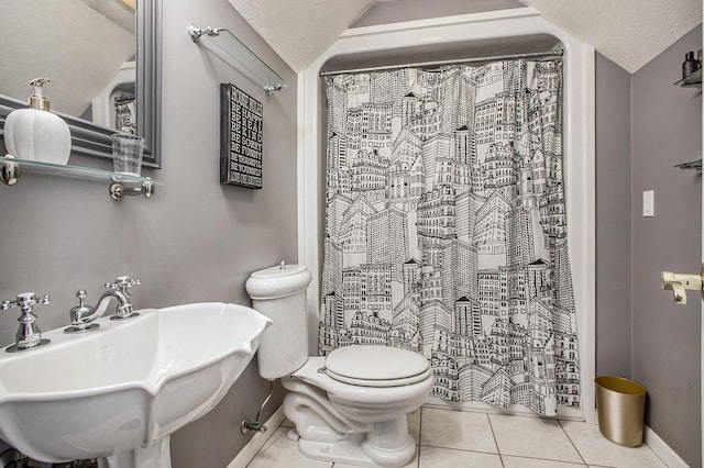 bathroom with lofted ceiling, sink, tile patterned flooring, a textured ceiling, and toilet