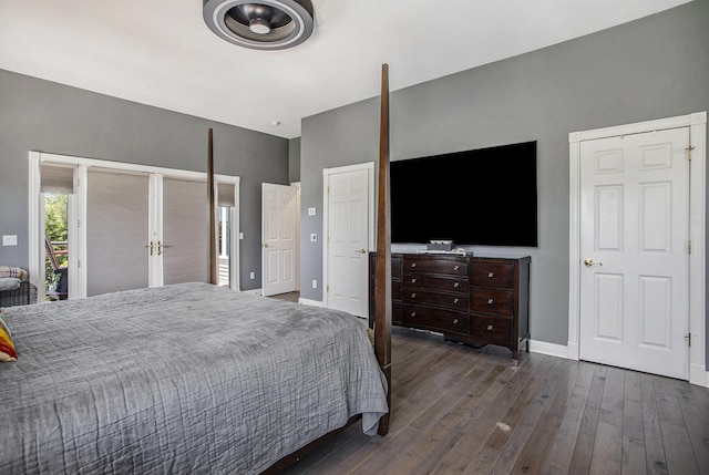 bedroom with dark hardwood / wood-style floors and multiple closets