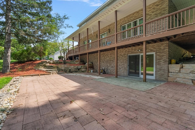 back of house featuring a patio area and brick siding