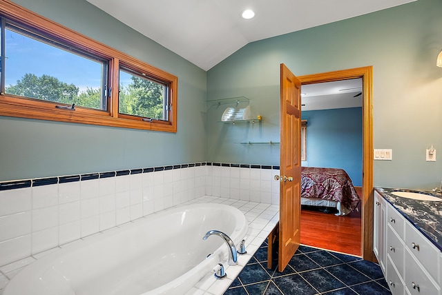 ensuite bathroom with tile patterned floors, ensuite bathroom, a garden tub, vaulted ceiling, and vanity