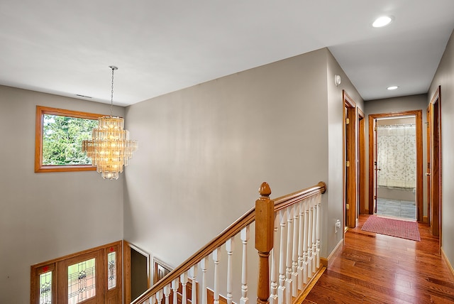 hall with recessed lighting, an upstairs landing, baseboards, dark wood finished floors, and an inviting chandelier