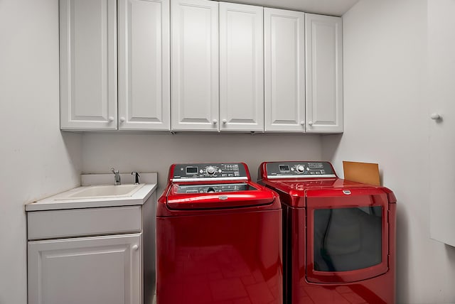 laundry room with a sink, cabinet space, and washer and dryer