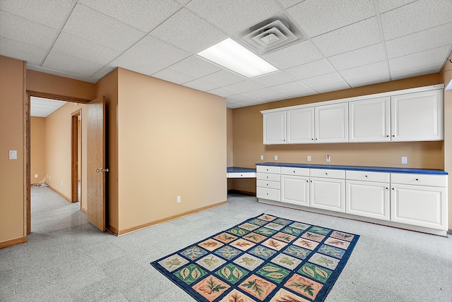 kitchen featuring dark countertops, visible vents, white cabinets, and a drop ceiling