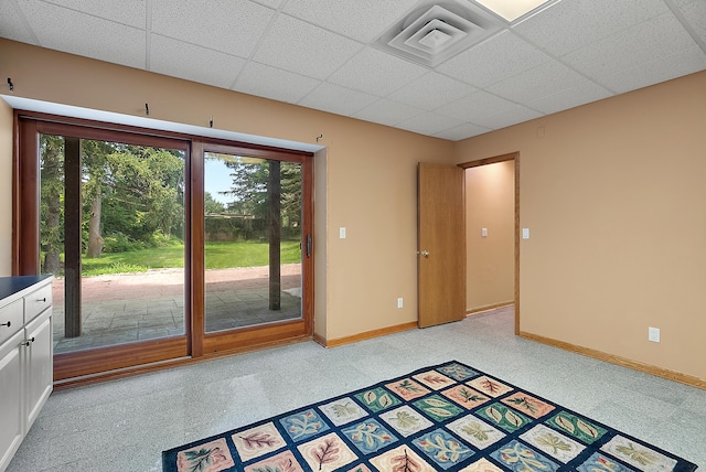 spare room with a paneled ceiling, a healthy amount of sunlight, visible vents, and baseboards