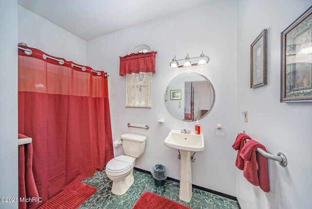 bathroom featuring sink, tile floors, and toilet