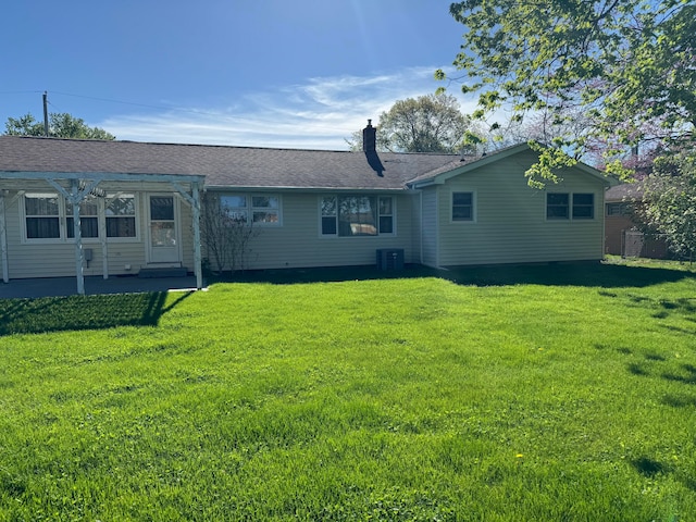 rear view of house with a lawn and central air condition unit