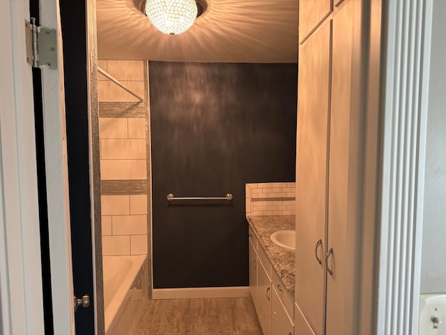 bathroom with wood-type flooring, vanity, and shower / bathtub combination