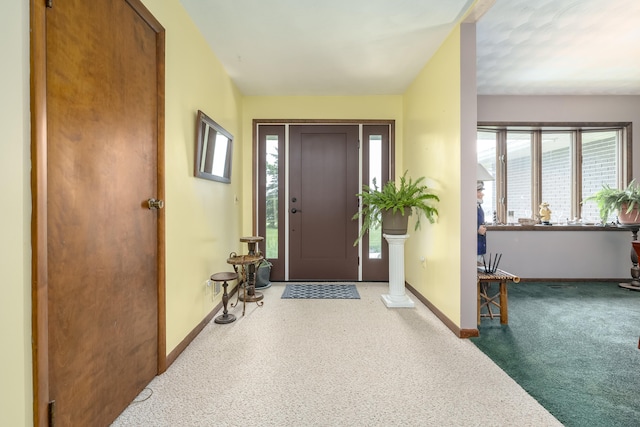 foyer entrance featuring carpet