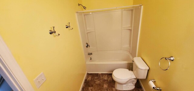 bathroom with washtub / shower combination, toilet, and tile patterned floors