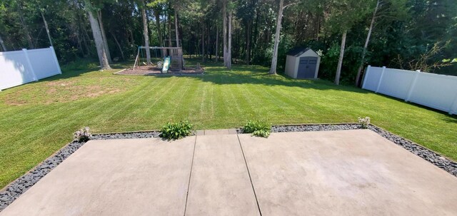 view of yard featuring a storage shed and a patio