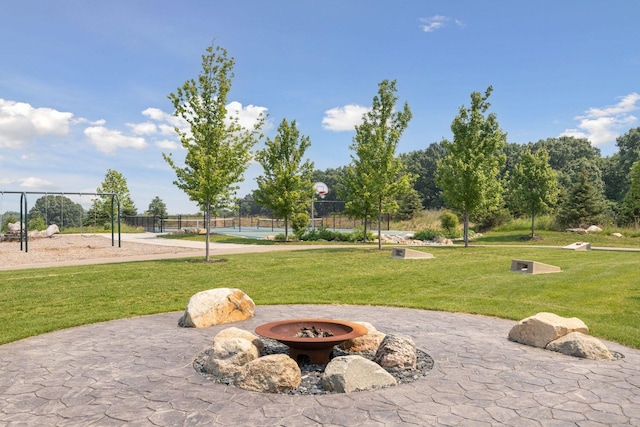 surrounding community with a yard, basketball court, and a fire pit