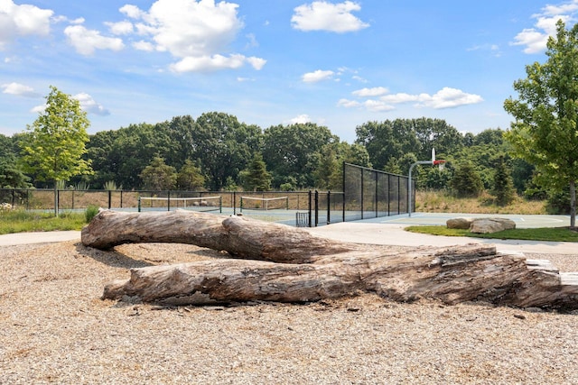 exterior space with tennis court and basketball hoop