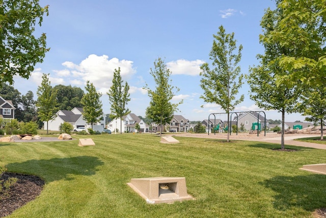 view of home's community featuring a playground and a yard