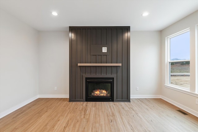 room details featuring hardwood / wood-style flooring and a large fireplace