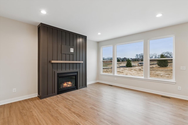 unfurnished living room with light hardwood / wood-style flooring and a fireplace