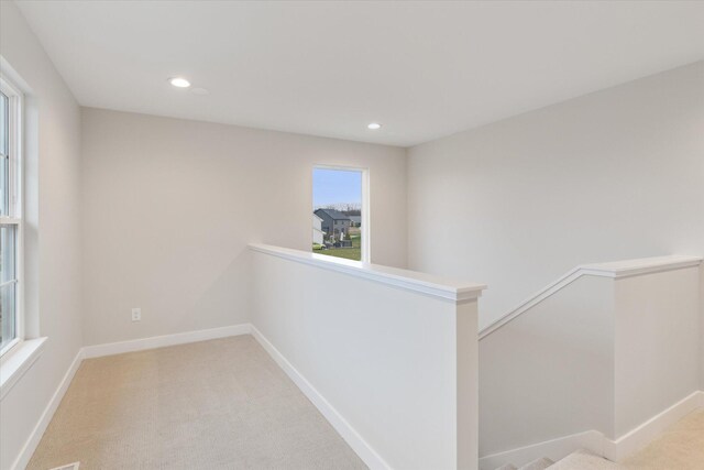 hallway with light colored carpet