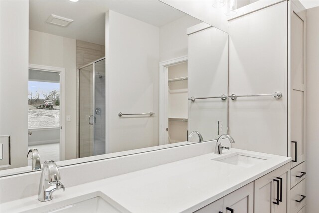 bathroom featuring walk in shower and vanity