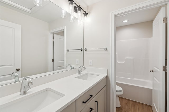 full bathroom featuring hardwood / wood-style floors, toilet, vanity, and  shower combination