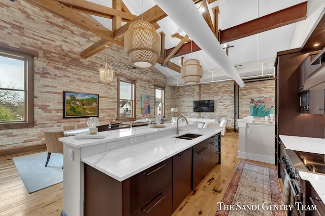 kitchen with light wood-type flooring, high vaulted ceiling, beamed ceiling, and brick wall