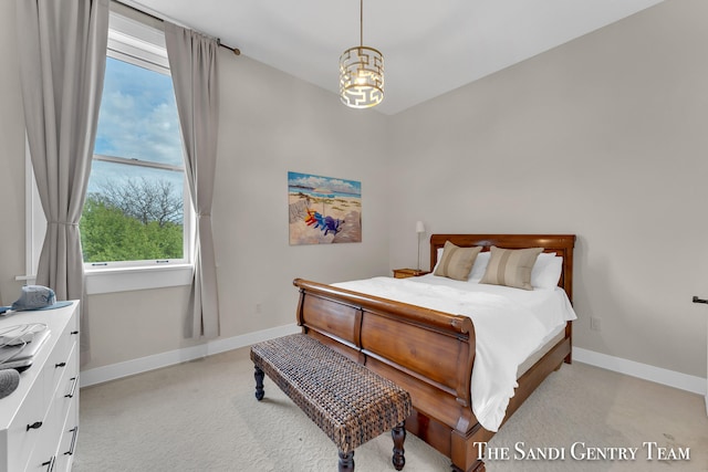 bedroom featuring an inviting chandelier and light colored carpet