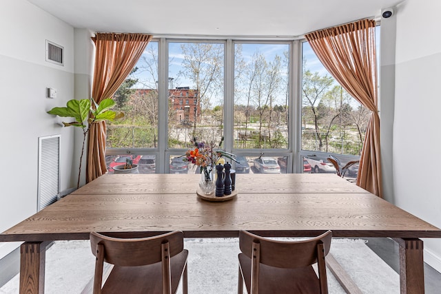 dining room featuring a wall of windows and a wealth of natural light