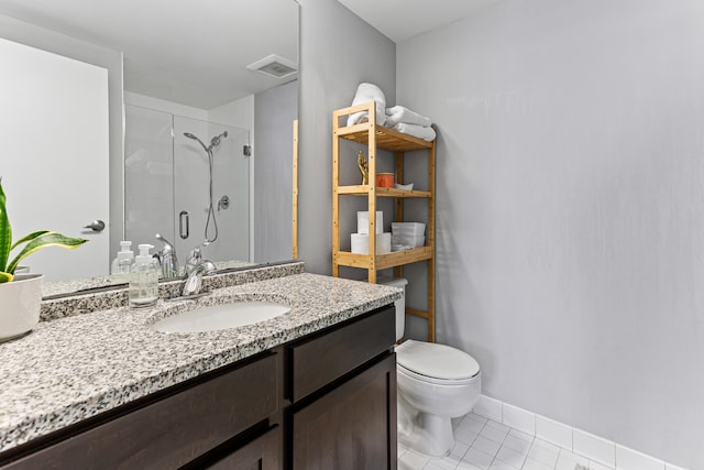 bathroom with a shower with door, vanity, tile patterned floors, and toilet