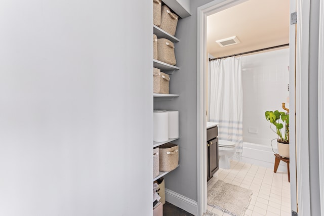 full bathroom with shower / tub combo with curtain, tile patterned floors, toilet, and vanity