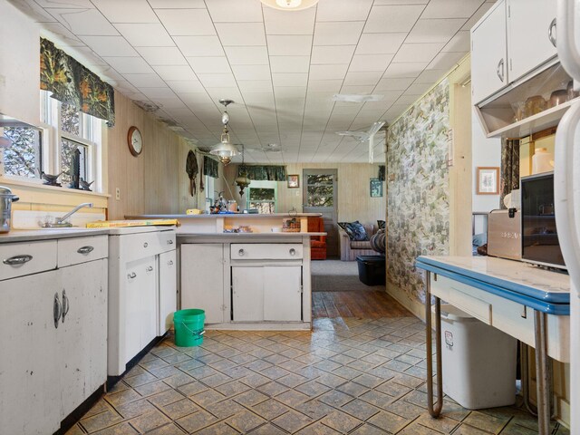 kitchen with white cabinets, tile flooring, and decorative light fixtures