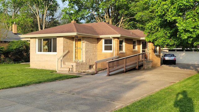 view of front of house with a garage, an outdoor structure, and a front yard