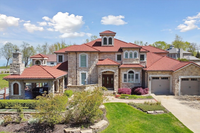 mediterranean / spanish home with a garage and a front lawn