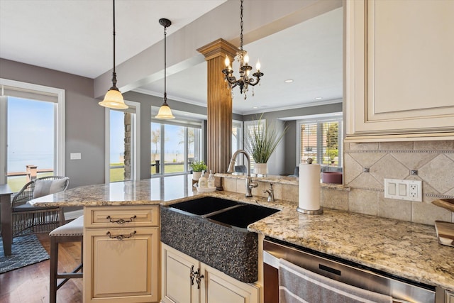 kitchen with decorative light fixtures, dishwasher, dark hardwood / wood-style floors, tasteful backsplash, and light stone counters