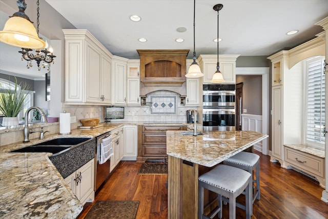 kitchen with backsplash, dark wood-type flooring, appliances with stainless steel finishes, and a kitchen island with sink