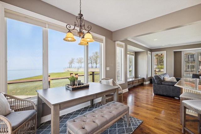 dining area with dark hardwood / wood-style floors and an inviting chandelier