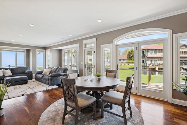 dining area with hardwood / wood-style flooring, crown molding, and a healthy amount of sunlight