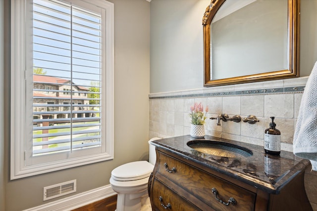 bathroom with wood-type flooring, large vanity, tasteful backsplash, and toilet