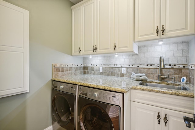 washroom featuring sink, cabinets, and washer and clothes dryer