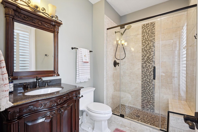 bathroom with a shower with door, toilet, tile floors, and large vanity