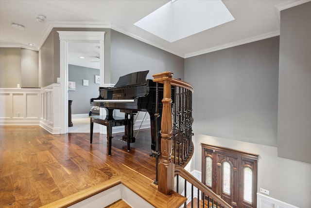 interior space with a skylight, crown molding, and hardwood / wood-style flooring